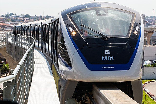 Monotrilho da linha 15 Prata entrando em estação durante período de testes. Na foto, o veículo é visto de frente sob o sol forte. Na frente do veículo pode-se ler M01 e Bombardier, nome do fabricante.